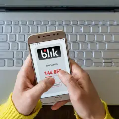 Ręce trzymają telefon z aplikacją Blik, pokazując kod. To może być pomocne, gdy zastanawiasz się, jak odzyskać pieniądze z przelewu oszustwa.