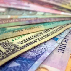 Różne waluty świata ułożone wachlarzowo, od dolara amerykańskiego po banknoty z Singapuru i Sri Lanki. Ile jest walut na świecie? Tyle, ile widzisz tutaj i jeszcze więcej!