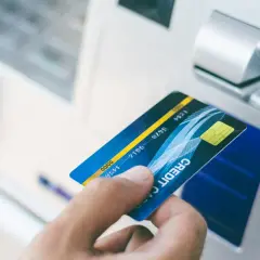 Dłoń z kartą zbliża się do wpłatomatu. Zastanawiasz się, ile można wpłacić we wpłatomacie?