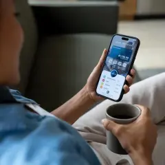 Kobieta sprawdza saldo po operacji na telefonie, widoczny jest wynik $1,730.50.