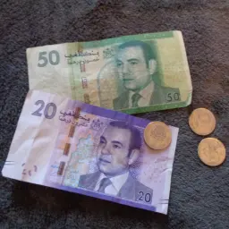 Banknoty 20 i 50 dirhamów, czyli jaka waluta w Maroku, leżą obok monet.