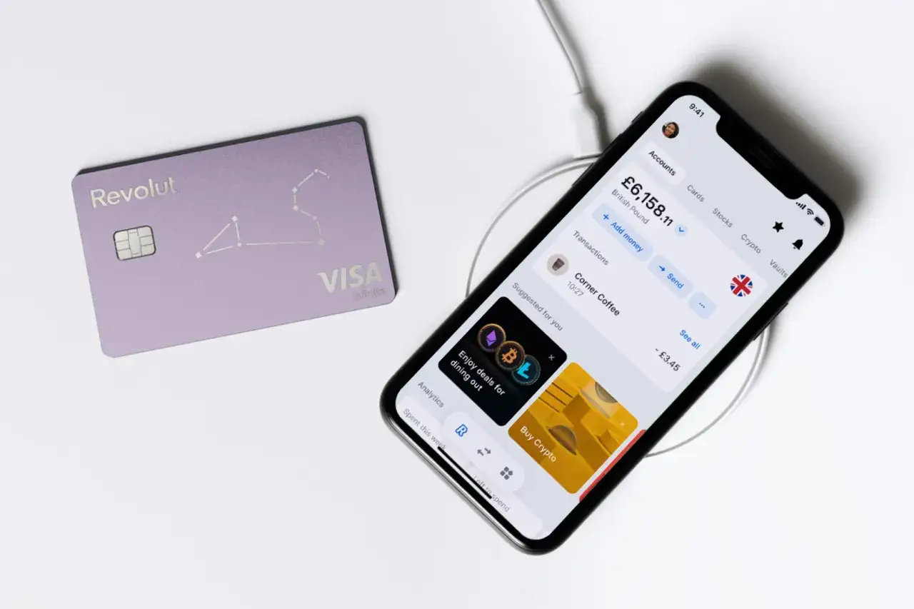 Fioletowa karta Revolut i smartfon z aplikacją bankową. To pokazuje, revolut co to – nowoczesny sposób zarządzania finansami.